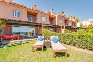 two chairs and a hammock in the yard of a house at Beachfront Townhouse Estepona in Estepona