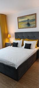 - une chambre dotée d'un grand lit avec des draps et des oreillers blancs dans l'établissement Apartament Faleza Nord, à Constanţa