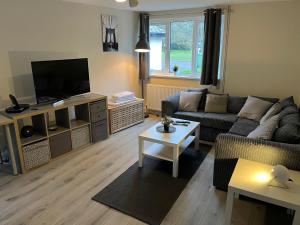 a living room with a couch and a tv at 5 Bed Camberley Airport Accommodation in Camberley