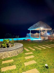 a swimming pool with a gazebo at night at The Heyday in Vagamon
