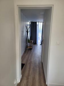 a hallway with white walls and wooden floors at Les oursins-appartement 3pièces, 4 couchages et parking gratuit in Metz