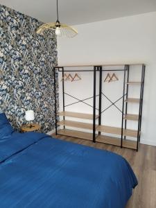 um quarto com uma cama azul e uma parede em Les oursins-appartement 3pièces, 4 couchages et parking gratuit em Metz