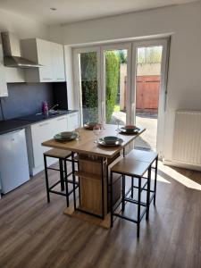 cocina con mesa de madera y sillas en Les oursins-appartement 3pièces, 4 couchages et parking gratuit en Metz