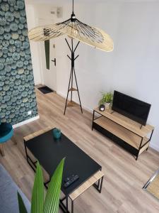 uma sala de estar com uma mesa e uma televisão em Les oursins-appartement 3pièces, 4 couchages et parking gratuit em Metz