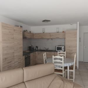 ein Wohnzimmer mit einem Sofa und einem Tisch in der Küche in der Unterkunft Paisible P2 pour 4 voyageurs in Saint-Gilles