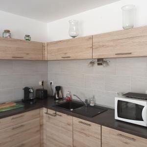 a kitchen with a sink and a microwave at Paisible P2 pour 4 voyageurs in Saint-Gilles