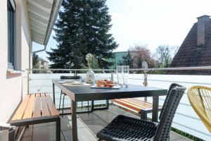 a patio with a table and chairs on a balcony at Lumen Homes - Design-Apt. nahe Audi und Altstadt, 3 Zimmer, NETFLIX in Ingolstadt