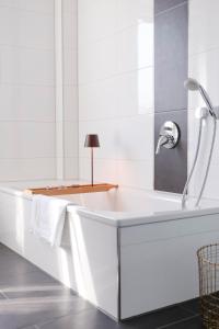 a white bathroom with a tub and a sink at Lumen Homes - Design-Apt. nahe Audi und Altstadt, 3 Zimmer, NETFLIX in Ingolstadt