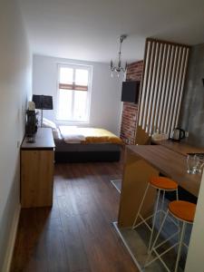 ein Schlafzimmer mit einem Bett und eine Küche mit einem Tisch in der Unterkunft Pokoje Gościnne FABIO in Chojnice