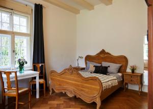 a bedroom with a wooden bed and a table and a desk at Schloss Mörlbach in Mörlbach
