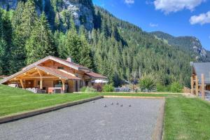 a house with a pond in front of a mountain at Anna - Chalet - BO Immobilier in Châtel