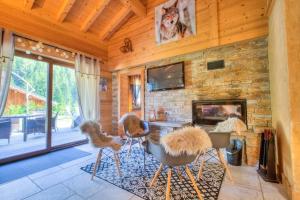 a living room with chairs and a stone fireplace at Anna - Chalet - BO Immobilier in Châtel