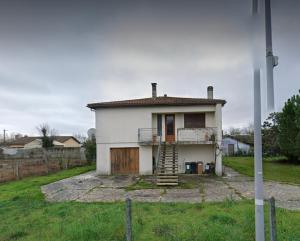 Casa blanca pequeña con porche y escalera en Maison OK riba Aéroport Mérignac, en Mérignac