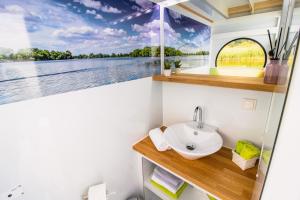 a bathroom with a sink and a window with a view at Hausboot FIONA im Yachthafen Berlin - Schmöckwitz - Spree und Müggelsee in Berlin