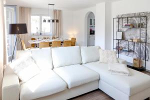 a white couch in a living room with a table at Lumen Homes - Design-Apt. nahe Audi und Altstadt, 3 Zimmer, NETFLIX in Ingolstadt