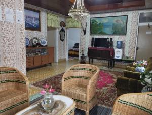 a living room with wicker chairs and a table at Hasbi Homestay Syariah in Bukittinggi