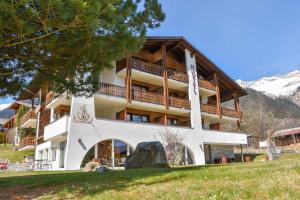 a large apartment building in the mountains at Hotel Pazzola in Disentis