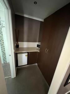 a small kitchen with brown walls and a white appliance at Pevensey Motor Lodge in Echuca