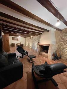 uma sala de estar com um sofá e uma lareira de pedra em Casa Rural Cal Casetó em Font-Rubí