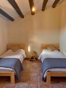 een slaapkamer met 2 bedden in een kamer bij Casa Rural Cal Casetó in Font-Rubí