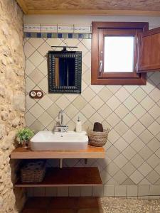 La salle de bains est pourvue d'un lavabo et d'un miroir. dans l'établissement Casa Rural Cal Casetó, à Font-Rubí