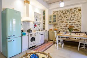 Kroústas的住宿－Konstantis，厨房配有蓝色冰箱和桌子