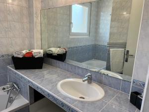 a bathroom with a sink and a mirror and a tub at T3 Spacieux lumineux, climatisé in Montpellier