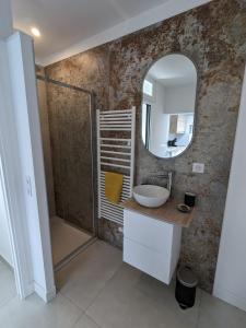 ein Bad mit einem Waschbecken und einem Spiegel in der Unterkunft Maison rouge in Millau
