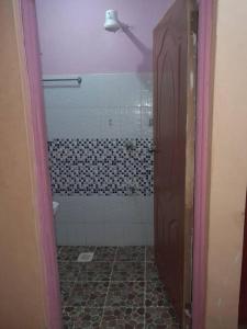 baño con ducha y aseo y suelo de baldosa. en Goldy haven studio apartment Nyeri, en Nyeri