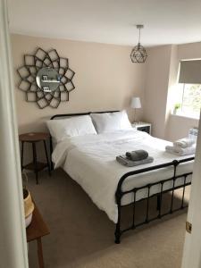 a bedroom with a large bed with white sheets at SEREN cottage by the sea in Llangadwaladr