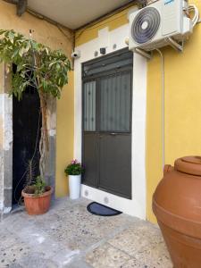 una puerta de garaje negra con un ventilador en el lateral de una casa en U cuttigghiu en Catania