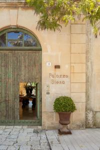 米內爾維諾迪萊切的住宿－Palazzo Siena - Home & More，前面有门的商店和前面的植物