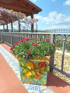 a vase filled with flowers sitting on a fence at Agriturismo le Campanelle - Sicilia - Cefalù in Lascari