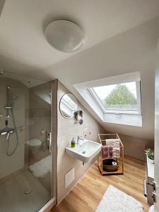 a bathroom with a sink and a shower and a window at Ferienwohnung Rein in Oberteuringen