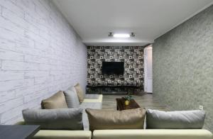 a living room with a couch and a tv at Vila Keluarga Syariah Mawar 82, Dago Resort 4BR dengan Privat Pool BBQ dan Rooftop in Bandung