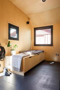 a bed in a small room with two windows at Tiny House in the countryside in Årnes