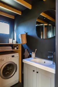 a bathroom with a sink and a washing machine at Tiny House in the countryside in Årnes