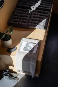 a bed with a blanket on a table with shoes at Tiny House in the countryside in Årnes