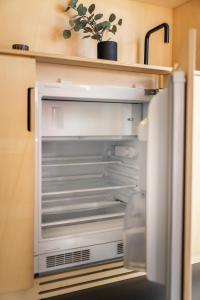 una puerta vacía del refrigerador está abierta en una cocina en Tiny House in the countryside en Årnes