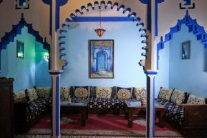a living room with blue walls and a couch at Riad Nerja in Chefchaouen
