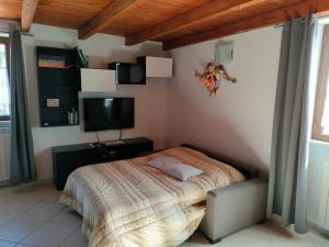 1 dormitorio con 1 cama y TV de pantalla plana en Il Rifugio di Farinella, en Putignano