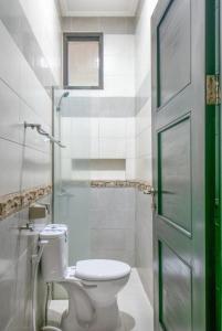La salle de bains est pourvue de toilettes et d'une douche en verre. dans l'établissement Vila Keluarga Syariah Mawar 82, Dago Resort 4BR dengan Privat Pool BBQ dan Rooftop, à Bandung