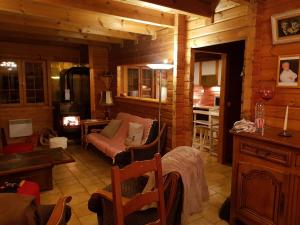 een woonkamer met een bank en een stoel bij Chalet Henri classé 3 étoiles aux Portes du Soleil in Montriond