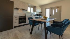 a kitchen with a wooden table and blue chairs at Farm House in Vlachata
