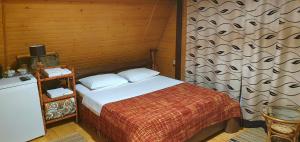 a bedroom with a bed and a wooden wall at Kozatskiy Dvir in Stryi