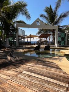 a swimming pool with a gazebo and palm trees at Villa Bamboo in Coyuca