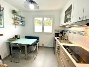 a small kitchen with a table and a sink at CAP SUD 83 APPART VUE MER 200m plages in Hyères