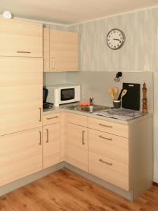 une cuisine avec des armoires en bois et une horloge au mur dans l'établissement Vintagetraum, à Gevelsberg