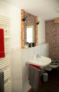 La salle de bains est pourvue d'un lavabo blanc et d'un mur en briques. dans l'établissement Vintagetraum, à Gevelsberg
