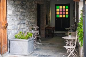 a patio with tables and chairs and a stained glass door at Cadepulan in Como